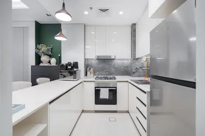 a kitchen with white cabinets and a stove at Luxury 1BHK Apartment Nobles Tower, Business Bay in Dubai