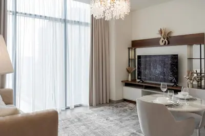 a living room with a dining table and a television at 1BR - Peninsula One in Dubai
