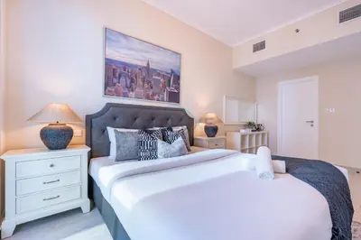a bedroom with two beds and a painting on the wall at 2BR, Seaside Serenity, Sea View - Torch Tower, Dubai Marina by Deluxe Holiday Homes in Dubai