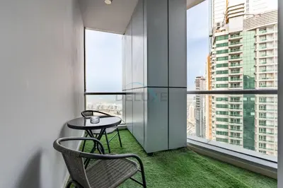 a table and a chair in a room with a window at 2BR, Seaside Serenity, Sea View - Torch Tower, Dubai Marina by Deluxe Holiday Homes in Dubai