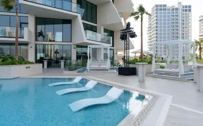a large building with a swimming pool in front of it at Premium 1BR W Private Pool Binghatti Royale in Dubai