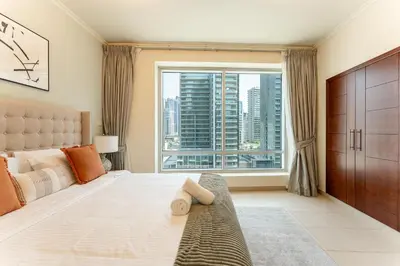 a bedroom with a bed and a large window at HAVN - 1 Bedroom in Downtown Dubai in Dubai