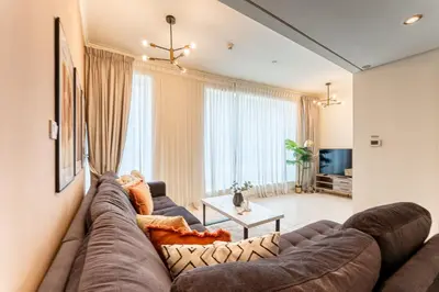 a living room with a large couch and a large window at HAVN - 1 Bedroom in Downtown Dubai in Dubai