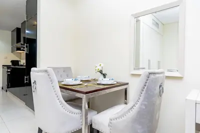 a dining room with a table and two chairs at Nasma Luxury stays - Executive stay with hotel facilities in Dubai