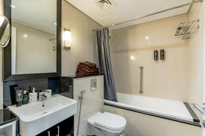 a bathroom with a sink and a toilet and a tub at Nasma Luxury stays - Executive stay with hotel facilities in Dubai