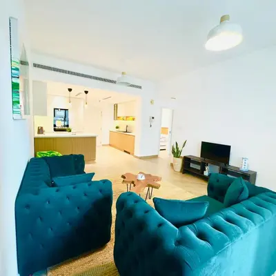 a living room with a blue couch and a table at Elegant apartment in a prime location in Dubai