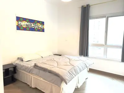 a bedroom with a bed in a room with a window at Elegant apartment in a prime location in Dubai