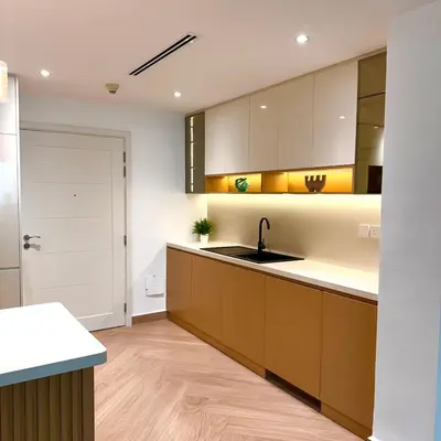 a kitchen with brown cabinets and a sink and a door at Elegant apartment in a prime location in Dubai
