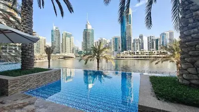 a swimming pool with a city skyline in the background at Bright, modern flat on the Marina Promenade in Dubai
