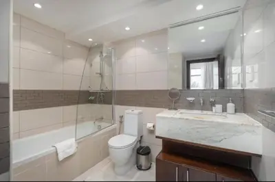 a bathroom with a tub and a toilet and a sink at Bright, modern flat on the Marina Promenade in Dubai