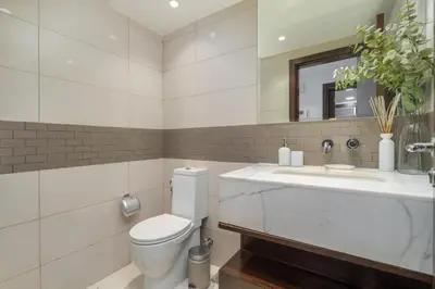 a bathroom with a toilet and a sink and a mirror at Bright, modern flat on the Marina Promenade in Dubai