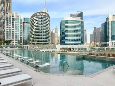 a swimming pool in a city with tall buildings at VayK - Luxury 1 BD with Panoramic Canal Views in Dubai