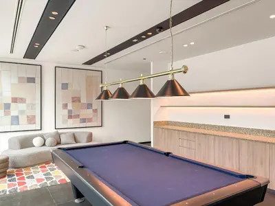 a pool table in a living room with a bill at VayK - Luxury 1 BD with Panoramic Canal Views in Dubai