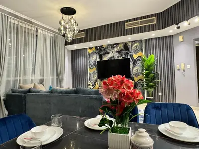 a living room with a table and a blue couch at Spacious 2BR Apartment-Marina Walk Luxury Stay-Enjoy Dubai Marina Views in Dubai