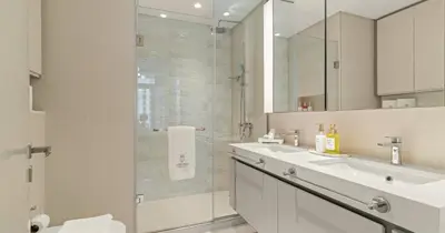 a white bathroom with a sink and a shower at Luxury 3BHK & Maid Sea View & Private Beach in Sabkhah