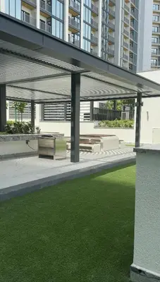 a pavilion with a bench and grass in a building at Superb 1BR high floor apartment on Sobha Hartland in Dubai