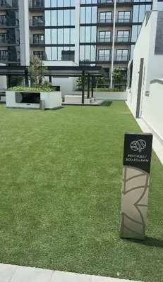 a lawn in front of a building with a sign on it at Superb 1BR high floor apartment on Sobha Hartland in Dubai