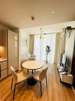a living room with a table and chairs and a couch at Superb 1BR high floor apartment on Sobha Hartland in Dubai