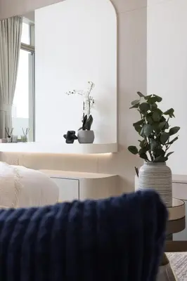 a living room with a couch and a vase with plants at Elegant Designer Studio with Balcony & Rooftop Pool in JVC in Dubai