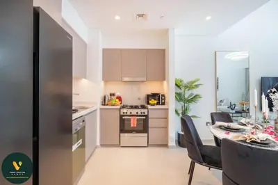 a kitchen with a table and a stove top oven at Vogue Downtown Act One near Burj Khalifa and Dubai Mall, Two Bedroom Apartment with Balcony and City Skyline View, Access to all Amenities in Dubai