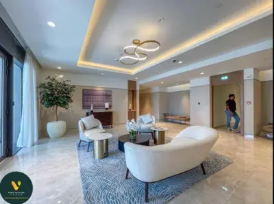a living room with white furniture and a person in the background at Vogue Downtown Act One near Burj Khalifa and Dubai Mall, Two Bedroom Apartment with Balcony and City Skyline View, Access to all Amenities in Dubai