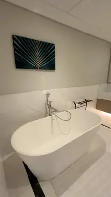 a white sink in a room with a picture on the wall at PALM TOWER by Design Studio 1 BR in Dubai