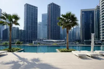 a swimming pool with palm trees and a city skyline at Luxury 1 Bedroom - Burj Khalifa & sea view - Sauna & Pool - High Floor in Dubai