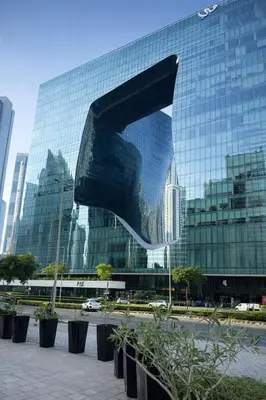 a large glass building with a sculpture in front of it at Luxury 1 Bedroom - Burj Khalifa & sea view - Sauna & Pool - High Floor in Dubai