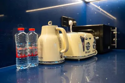 a toaster and two bottles of water on a counter at Luxury 1 Bedroom - Burj Khalifa & sea view - Sauna & Pool - High Floor in Dubai