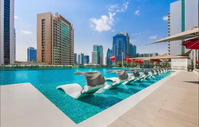 a row of chaise lounge chairs next to a swimming pool at Mag318 Luxury 5 Minutes to Burj&mall in Dubai