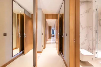 a corridor of a bathroom with a toilet and a sink at 3br on the 49th floor of Address Opera in Dubai