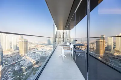 a balcony with a table and chairs on top of a building at 3br on the 49th floor of Address Opera in Dubai