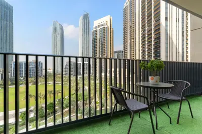 a balcony with a table and chairs and a city at Premium 2BR with Park View in Dubai Creek Harbour in Dubai