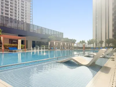 a swimming pool with chairs in the middle of a building at Premium 2BR with Park View in Dubai Creek Harbour in Dubai