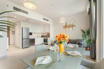 a dining room with a glass table with flowers on it at Premium 2BR with Park View in Dubai Creek Harbour in Dubai