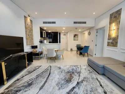 a living room with a couch and a dining room at Golden Grove 1 Bhk Bays Edge 1 Business bay in Dubai