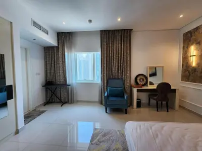 a living room with a desk and a blue chair at Golden Grove 1 Bhk Bays Edge 1 Business bay in Dubai