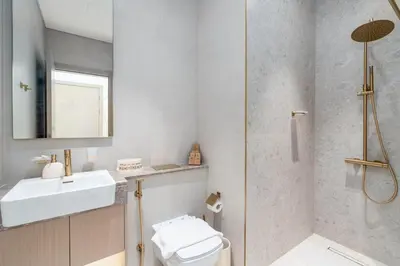 a bathroom with a toilet and a sink and a shower at Private pool, Paddle court, Sauna and Hammam - Binghatti Royal in Dubai