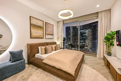 a bedroom with a couch and a large window at Stylish Studio with views of pool & Burj Khalifa in Dubai