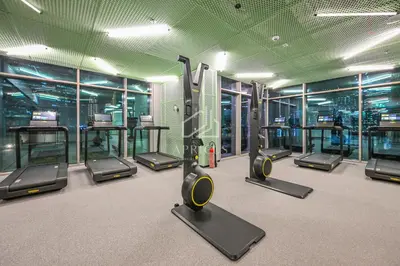 a gym with a bunch of treadms and machines at Stylish Studio with views of pool & Burj Khalifa in Dubai