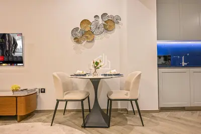 a dining room with a table and two chairs at Stylish Studio with views of pool & Burj Khalifa in Dubai