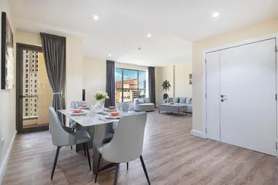 a dining room and living room with a table and chairs at Stunning 2BR with Sea View Murjan 1 Near Beach in Dubai