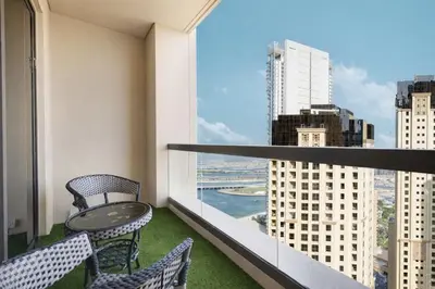 a balcony with a table and chairs and a view of a city at Stunning 2BR with Sea View Murjan 1 Near Beach in Dubai