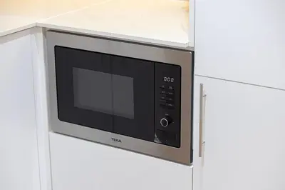 a microwave oven hanging on a kitchen cabinet at Stunning 2BR with Sea View Murjan 1 Near Beach in Dubai