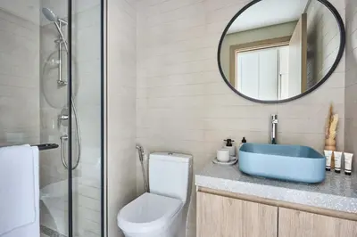 a bathroom with a toilet and a sink and a mirror at Frank Porter - Peninsula One in Dubai