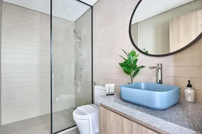 a bathroom with a blue sink and a mirror at Frank Porter - Peninsula One in Dubai