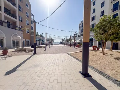 an empty street in a city with buildings at Frank Porter - La Voile 3, La Mer in Dubai