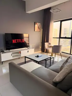 a living room with a couch and a tv at 1BR in Dubai Marina with Marina Skyline Views in Dubai