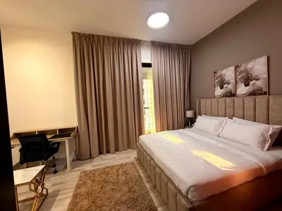 a bedroom with a bed and a desk and a window at 1BR in Dubai Marina with Marina Skyline Views in Dubai