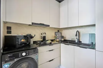 a kitchen with a washing machine and a microwave at Frank Porter - J One Tower, Business Bay in Dubai